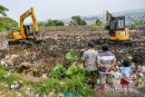 Warga melihat alat berat yang dioperasikan petugas di Tempat Pembuangan Sampah Akhir (TPA) Cicabe, Bandung, Jawa Barat, Kamis (18/5/2023). Pemerintah Kota Bandung menonaktifkan kembali TPA Cicabe seiring dengan operasional TPA Sarimukti yang mulai kembali normal. ANTARA FOTO/Raisan Al Farisi/agr
