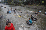 Sejumlah anak bermain air dengan menggunakan ban karet di Sungai Ciliwung, Katulampa, Kota Bogor, Jawa Barat, Kamis (18/5/2023). Mereka memanfaatkan sungai tersebut sebagai tempat bermain untuk mengisi hari libur. ANTARA FOTO/Yulius Satria Wijaya/tom.
