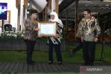 Menteri Pan-RB Abdallah  Azwar Anas (kiri) didampingi Kepala Arsip Nasional Republik  Indonesia (ANRI) Imam Gunarto memberikan piagam penghargaan kepada Gubernur  Jawa Timur Khofifah Indar Parawansa(tengah)  pada acara puncak Kegiatan Hari kearsipan Nasional di Banyuwangi, Jawa Timur, Senin (22/5/2023). Arsip Nasional Republik Indonesia (ANRI) memberikan lima penghargaan kepada Gubernur Jawa Timur diantaranya penghargaan hasil pengawasan kearsipan tahun 2022 tingkat provinsi serta penghargaan tokoh kepemimpinan kearsipan dalam penyelamatan dan pelestarian arsip sebagai memori kolektif bangsa. ANTARA Jatim/Budi Candra Setya/zk 