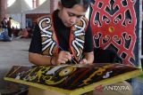 Lomba melukis perisai Dayak. Peserta mengikuti lomba melukis perisai di arena Pekan Gawai Dayak ke-37 di Rumah Radakng, Pontianak, Kalimantan Barat, Senin (22/5/2023). Lomba melukis motif simbol-simbol khas Dayak dengan dominasi warna merah, kuning, putih dan hitam di atas papan perisai yang diikuti 42 peserta tersebut diselenggarakan untuk melestarikan seni budaya Suku Dayak. ANTARA FOTO/Jessica Helena Wuysang.