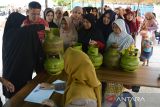 Warga antri berbelanja gas elpiji bersubsidi 3 kilogram  saat berlangsung operasi pasar murah keliling masuk desa di Banda Aceh, Aceh, Selasa (23/5/2023). Operasi pasar murah keliling melibatkan Dinas Koperasi UMKM dan Pertamina yang menjual beberapa jenis komoditas pangan dan gas elpiji bersubsidi 3 kilogram bersamaan dengan mulai naiknya harga sebagian  bahan pokok sejak beberapa hari terakhir di pasar tradisional daerah itu untuk menstabilkan harga dan pengendalian inflasi daerah. ANTARA FOTO/Ampelsa.