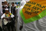 Petugas haji Kementerian Agama melayani jamaah calon haji berusia lanjut kloter pertama embarkasi Aceh yang menggunakan kursi roda saat tiba di asrama haji Banda Aceh, Aceh, Selasa (23/5/2023). Pada musim haji 2023 Direktorat Jenderal Penyelenggaraan Haji dan Umrah (PHU) Kemenag telah mengangkat tema Haji Ramah Lansia dengan jumlah jamaah calon haji berusia lanjut mencapai 67 ribu jamaah dan 4.000 diantaranya menggunakan kursi roda. Antara Aceh/Irwansyah Putra