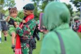 Prajurit Raider menggendong anaknya yang menangis usai upacara penyambutan Satgas Pengamanan Perbatasan Papua Nugini Yonif Raider 142/Ksatria Jaya di Batalyon Infanteri Raider 142/Ksatria Jaya, Jambi, Senin (22/5/2023). Sebanyak 400 prajurit Yonif 142/Ksatria Jaya yang melakukan tugas pengamanan perbatasan RI-Papua Nugini selama 14 bulan kemarin di Papua telah tiba di Jambi. ANTARA FOTO/Wahdi Septiawan/aww.