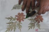 Perajin membuat motif daun dengan teknik 