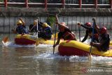 Dua tim peserta beradu melajukan perahu karetnya saat Kejuaraan Dayung Obstacle Race Piala Wali Kota Surabaya di Sungai Kalimas, Surabaya, Jawa Timur, Jumat (26/5/2023). Kejuaraan yang diikuti  47 tim peserta dari berbagai daerah di Jawa Timur itu merupakan  salah satu rangkaian kegiatan untuk menyemarakkan Hari Jadi ke-730 Kota Surabaya. ANTARA Jatim/Didik Suhartono/zk 