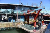 Petugas memeriksa hasil tangkapan ikan kapal trawl  usai penangkapan di Pelabuhan Perikanan Samudera (PPS) Banda Acerh, Aceh, Sabtu (27/5/2023). Pangkalan Pengawasan Sumber Daya Kelautan dan Perikanan (PSDKP) menangkap dua unit kapal ikan Indonesia, KM Surya Citra dan KM Laot Jaya di perarian Langsa dan Lhokseumawe, provinsi Aceh karena menggunakan trawl , tanpa dilengkapi dokumen dan mengamankan sebanyak 15 ABK . ANTARA FOTO/Ampelsa.