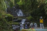 Pengunjung menikmati pemandangan situs geopark meratus air terjun Kilat Api di Kecamatan Loksado, Kabupaten Hulu Sungai Selatan, Kalimantan Selatan, Selasa (30/5/2023). Air terjun yang merupakan salah satu kawasan Geopark Meratus itu selain menawarkan panorama yang indah wisata air terjun tersebut juga memiliki sejarah geologi kawasan yang berada di Pegunungan Meratus yaitu pada Granit Batanglai atau Belawayan yang berumur Kapur Awal (95-135) juta tahun lalu. ANTARA/Bayu Pratama S.