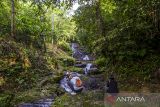 Pengunjung menikmati pemandangan situs geopark meratus air terjun Kilat Api di Kecamatan Loksado, Kabupaten Hulu Sungai Selatan, Kalimantan Selatan, Selasa (30/5/2023). Air terjun yang merupakan salah satu kawasan Geopark Meratus itu selain menawarkan panorama yang indah wisata air terjun tersebut juga memiliki sejarah geologi kawasan yang berada di Pegunungan Meratus yaitu pada Granit Batanglai atau Belawayan yang berumur Kapur Awal (95-135) juta tahun lalu. ANTARA/Bayu Pratama S.