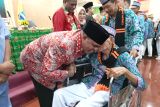 Bupati Manokwari, Papua Barat, Hermus Indou memeluk satu jamaah calon haji lanjut usia yang akan diberangkatkan ke embarkasi Makassar, Sulawesi Selatan, selanjutnya menuju Tanah Suci. 