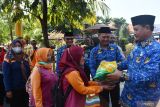 Wali Kota Madiun Maidi (kanan) memberikan bantuan beras dan minyak goreng kepada tenaga kebersihan jalan di Kota Madiun, Jawa Timur, Kamis (1/6/2023). Menurut Wali Kota Maidi, bantuan bahan pokok kepada tukang becak dan tenaga kebersihan jalan pada peringatan Hari Lahir Pancasila tersebut sebagai salah satu bentuk pengamalan Pancasila. Antara Jatim/Siswowidodo/zk.