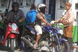 Petugas berpakaian adat melayani konsumen yang membeli bahan bakar minyak (BBM) di Stasiun Pengisian Bahan Bakar Umum (SPBU) Beran, Ngawi, Jawa Timur, Kamis (1/6/2023). Seluruh karyawan di SPBU tersebut mengenakan baju adat untuk memperingati hari lahir Pancasila sekaligus mensosialisasikan penggunaan aplikasi My Pertamina untuk pembelian bbm. Antara Jatim/Ari Bowo Sucipto/zk.