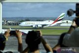 Warga menyaksikan pendaratan pesawat Airbus A380 milik maskapai penerbangan Emirates di Bandara Internasional I Gusti Ngurah Rai, Badung, Bali, Kamis (1/6/2023). Pendaratan pesawat komersial terbesar di dunia dengan nomor penerbangan EK368 dari Dubai menuju Bali tersebut menjadi penerbangan komersil pesawat A380 pertama di Indonesia. ANTARA FOTO/Fikri Yusuf/wsj.