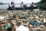 Karyawati PLN Unit Pelaksana Pelayanan Pelanggan (UP3) Lhokseumawe mengambil sampah dengan menggunakan perahu saat aksi bersih sampah PLN Peduli di waduk  Lhokseumawe, Aceh. Jumat (9/6/2023). Aksi bersih sampah PLN Peduli tersebut merupakan program Tanggung Jawab Sosial Lingkungan (TJSL)  dalam rangka memperingati Hari Lingkungan Hidup Sedunia. ANTARA/Rahmad