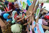 Seorang anak menempelkan gambar daun pada replika pohon dari kardus di Makara Universitas Indonesia, Depok, Jawa Barat, Kamis (8/6/2023). BAKUL Budaya Fakultas Ilmu Pengetahuan Budaya UI mengadakan kegiatan edukasi mengenai lingkungan dengan mendongeng dan menggambar untuk memperingati Hari Lingkungan Hidup Sedunia. ANTARA FOTO/Asprilla Dwi Adha/nym.