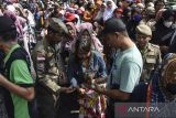Warga antre saat pembagian jajanan gratis di Komplek DPRD Kabupaten Ciamis, Jawa Barat, Senin (12/6/2023). Pemerintah Kabupaten Ciamis menyediakan makanan gratis bagi warga dengan melibatkan 130 pedagang kaki lima (PKL) dalam rangka HUT ke-381 Ciamis sebagai promosi dan pemasaran untuk pedagang kuliner. ANTARA FOTO/Adeng Bustomi/agr