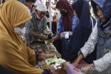 Warga menukarkan kupon makanan saat pembagian jajanan gratis di Komplek DPRD Kabupaten Ciamis, Jawa Barat, Senin (12/6/2023). Pemerintah Kabupaten Ciamis menyediakan makanan gratis bagi warga dengan melibatkan 130 pedagang kaki lima (PKL) dalam rangka HUT ke-381 Ciamis sebagai promosi dan pemasaran untuk pedagang kuliner. ANTARA FOTO/Adeng Bustomi/agr