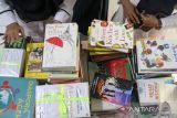 Penjabat Wali Kota Lhokseumawe Imran (kedua kiri) bersama pendidik dan pelajar menunjukkan buku bacaan usai penyerahan bantuan sejuta buku untuk Aceh di SMKN1 Lhokseumawe, Aceh, Rabu (14/6/2023). Bantuan buku yang dicetuskan Yayasan Forum Komunikasi Alumni Lhokseumawe di Jakarta (FoKAL) dan Seuramoe Syedara Lhokseumawe (Seusama) tersebut merupakan program bantuan buku untuk perpustakaan sekolah di 16 kabupaten/kota dalam rangka membantu pemerintah meningkatkan kualitas pendidikan di Aceh. ANTARA/Rahmad