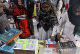 Penjabat Wali Kota Lhokseumawe Imran (kedua kiri) bersama pendidik dan pelajar menunjukkan buku bacaan usai penyerahan bantuan sejuta buku untuk Aceh di SMKN1 Lhokseumawe, Aceh, Rabu (14/6/2023). Bantuan buku yang dicetuskan Yayasan Forum Komunikasi Alumni Lhokseumawe di Jakarta (FoKAL) dan Seuramoe Syedara Lhokseumawe (Seusama) tersebut merupakan program bantuan buku untuk perpustakaan sekolah di 16 kabupaten/kota dalam rangka membantu pemerintah meningkatkan kualitas pendidikan di Aceh. ANTARA/Rahmad