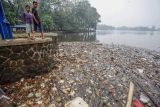 Dua orang anak melihat kondisi Situ Cikaret yang dipenuhi sampah rumah tangga di Cibinong, Kabupaten Bogor, Jawa Barat, Jumat (16/6/2023). Sampah rumah tangga yang sebagian besar memenuhi situ atau danau tersebut disebabkan kurangnya kepedulian warga sekitar untuk membuang sampah pada tempatnya sehingga berpotensi banjir saat hujan. ANTARA FOTO/Yulius Satria Wijaya/aww.