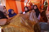 Peserta mengamati batik motif situs kawitan Alas Purwo pada pelatihan membatik di Tamansuruh Banyuwangi, Jawa Timur, Sabtu (17/6/2023). Direktorat Kepercayaan terhadap Tuhan yang Maha Esa dan Masyarakat Adat Kemendikbudristek bekerjasama dengan Perempuan AMAN Osing Banyuwangi menggelar pelatihan membatik cap motif Ijen Geopark sebagai upaya membuka lapangan kerja baru sehingga berdampak pada kesejahteraan perempuan adat. Antara Jatim/Budi Candra Setya/zk.