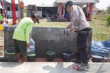Personel polisi bersama warga mencoba saluran air bersih di Losarang, Indramayu, Jawa Barat, Senin (19/6/2023). Polda Jabar memberikan bantuan saluran air bersih untuk masyarakat di daerah yang sulit mendapat akses air bersih terutama saat musim kemarau. ANTARA FOTO/Dedhez Anggara/agr