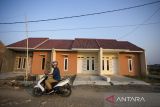 Warga melintas di sekitar perumahan yang baru selesai dibangun di Indramayu, Jawa Barat, Rabu (21/6/2023). Kementerian Keuangan menetapkan aturan baru mengenai batas harga rumah bersubsidi bebas Pajak Penambahan Nilai (PPN) dengan batas maksimal rumah yang diberi pembebasan PPN sebesar Rp162 juta hingga Rp240 juga dari harga sebelumnya sebesar Rp150,5 juta hingga Rp210 juta. ANTARA FOTO/Dedhez Anggara/agr