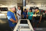 Petugas memberikan penjelasan terkait fungsi peralatan kepada sejumlah anggota Pramuka kwartir Sulawesi Utara saat Jambore Pramuka di atas KM Sinabung ketika sandar di Surabaya, Jawa Timur, Jumat (23/6/2023). Kegiatan jambore tersebut bertujuan memperkenalkan sejumlah fasilitas yang disediakan kapal kepada penumpang serta fungsi peralatan yang terdapat di kapal itu. ANTARA Jatim/Rizal Hanafi/zk