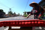 Warga suku Osing membersihkan kasur yang dijemur di depan rumahnya di Desa wisata Adat Kemiren, Banyuwangi, Jawa Timur, Kamis (22/6/2023). Mepe kasur atau menjemur kasur berwarna merah dan hitam itu merupakan tradisi turun temurun Suku Osing Kemiren untuk kegiatan bersih desa yang digelar setiap awal bulan Dzulhijah dengan tujuan agar terhindar dari penyakit. ANTARA Jatim/Budi Candra Setya/zk 