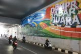Kendaraan melintas di samping dinding jalan dengan coretan vandalisme di Underpass Dewi Sartika, Depok, Jawa Barat, Selasa (27/6/2023). Aksi vandalisme yang dilakukan oleh oknum yang tidak bertanggung jawab tersebut dapat merusak keindahan jalan underpass Dewi Sartika yang telah diresmikan pada Januari 2023 lalu. ANTARA FOTO/Asprilla Dwi Adha/nym.