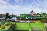 Pedagang berinteraksi dengan wisatawan mancanegara di kawasan situs Geopark Meratus wisata Pasar Terapung Lok Baintan, Kabupaten Banjar, Kalimantan Selatan, Rabu (28/6/2023). Pasar terapung Lok Baintan masuk menjadi salah satu situs Geopark Meratus yang menawarkan budaya kearifan lokal masyarakat banjar serta di ajukan ke Unesco Global Geopark (UGGp). ANTARA/Bayu Pratama S.