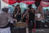 Anggota Polwan Polres Cimahi memasak rendang di Kantor Polres Cimahi, Cimahi, Jawa Barat, Rabu (28/6/2023). Sebanyak 300 paket berisi rendang dan beras 5 kg dibagikan Polres Cimahi kepada masyarakat guna menyambut Hari Raya Idul Adha 1444 Hijriah sekaligus rangkaian peringatan HUT ke-77 Bhayangkara. ANTARA FOTO/Novrian Arbi/agr