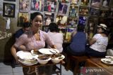 Pramusaji mengantarkan sajian kuliner ikan laut untuk pembeli di Warung Mak Beng, Sanur, Denpasar, Bali, Kamis (29/6/2023). Warung yang telah berdiri sejak tahun 1941 dengan menjual ikan laut goreng, sup kepala ikan laut dan sup sayur tersebut masuk dalam daftar restoran paling legendaris nomor tiga di dunia versi TasteAtlas. ANTARA FOTO/Fikri Yusuf/wsj.
