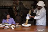 Koki menyajikan ikan timbungan atau hidangan tradisional khas Bali kepada wisatawan di Dapur Bali Mula, Desa Les Tejakula, Buleleng, Bali, Kamis (29/6/2023). Warung makan yang mengusung konsep dapur tradisional Bali tersebut menjadi daya tarik bagi wisatawan untuk berwisata kuliner dan menerapkan sistem pembayaran secara sukarela. ANTARA FOTO/Nyoman Hendra Wibowo/wsj.