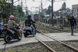 Kendaraan melintasi perlintasan kereta api sebidang di Bojonggede, Kabupaten Bogor, Jawa Barat, Selasa (4/7/2023). Berdasarkan data PT KAI hingga Mei 2023 terjadi 1.782 musibah kecelakaan lalu lintas di perlintasan sebidang, dengan jumlah perlintasan sebidang sebanyak 3.849 titik terdiri dari 1.447 titik dijaga dan 2.259 titik tidak dijaga. ANTARA FOTO/Yulius Satria Wijaya/rwa.