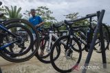 Petugas menata sepeda road bike yang akan dipertandingkan pada acara Cycling De Jabar 2023 di kawasan Geopark Ciletuh, Sukabumi, Jawa Barat, Jumat (7/7/2023). Pemerintah Provinsi Jawa Barat menggelar road bike pada 8-9 juli 2023 yang diikuti 154 peserta dari sejumlah daerah di Indonesia dan mancanegara dengan melintasi kawasan pesona Jawa Barat selatan dari geopark Ciletuh hingga Pangandaran sepanjang 369 km. ANTARA FOTO/Novrian Arbi/agr