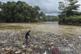 Warga mencari kayu ditumpukan sampah yang tersangkut di aliran Sungai Ciwulan, Kota Tasikmalaya, Jawa Barat, Sabtu (8/7/2023). Sampah yang didominasi plastik dan styrofoam itu berasal dari kebiasaan warga membuang sampah di sungai sehingga dapat mencemari ekosistem sungai dan dapat menyebabkan terjadi banjir saat musim hujan. ANTARA FOTO/Adeng Bustomi/agr