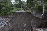 Sejumlah warga mengamati kondisi jembatan yang putus di wilayah Dusun Apet, Desa Selat, Klungkung, Bali, Sabtu (8/7/2023). Jembatan yang menghubungkan Desa Selat, Kabupaten Klungkung dengan Desa Tangkup, Kabupaten Karangasem tersebut putus pada Jumat (7/7) malam akibat meningkatnya debit air sungai saat terjadi hujan deras sehingga akses jalur pariwisata itu tidak bisa dilalui kendaraan dan ditutup sementara. ANTARA FOTO/Nyoman Hendra Wibowo/wsj.