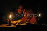 Seorang ibu mengajarkan anaknya mengaji dengan penerangan lampu minyak di rumahnya yang belum mendapatkan layanan listrik di Dusun Geragai, Desa Lagan Ulu, Tanjung Jabung Timur, Jambi, Minggu (9/7/2023). Warga setempat menyebutkan, sebanyak 86 kepala keluarga (KK) atau sekitar 300 jiwa lebih, warga di desa yang hanya berjarak belasan kilometer dari pusat pemerintahan Kabupaten Tanjung Jabung Timur itu belum mendapatkan layanan listrik meski telah puluhan tahun mengajukan permohonan. ANTARA FOTO/Wahdi Septiawan/Spt.