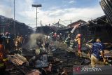 Sejumlah relawan pemadam kebakaran melakukan pendinginan sisa kebakaran di kawasan Teluk Tiram, Banjarmasin, Kalimantan Selatan, Rabu (12/7/2023). Penyebab kebakaran yang menghanguskan lima rumah dan satu Mushala tersebut masih dalam penyelidikan pihak berwajib. ANTARA/Bayu Pratama S.