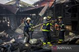 Sejumlah relawan pemadam kebakaran melakukan pendinginan sisa kebakaran di kawasan Teluk Tiram, Banjarmasin, Kalimantan Selatan, Rabu (12/7/2023). Penyebab kebakaran yang menghanguskan lima rumah dan satu Mushala tersebut masih dalam penyelidikan pihak berwajib. ANTARA/Bayu Pratama S.