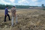 Ketua DPRD Provinsi Jambi Edi Purwanto (kanan) dan Kepala Desa Muaro Sebapo Wahyu Aditya (kiri) mengecek lokasi pembangunan Jalan Tol Bayung Lencir -Tempino Seksi 3 di Muaro Sebapo, Muaro Jambi, Jambi, Kamis (13/7/2023). Pembebasan lahan untuk pembangunan jalan tol yang menghubungkan Jambi dengan Sumatera Selatan sepanjang 15 kilometer lebih itu telah mencapai 96 persen dan ditargetkan dapat difungsikan pada Desember 2024 itu .ANTARA FOTO/Wahdi Septiawan/Spt.