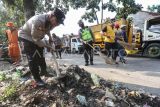 Anggota kepolisian Polres Metro Depok melakukan bersih-bersih sampah di area lingkungan TPA Cipayung, Depok, Jawa Barat, Kamis (13/7/2023). Kapolres Metro Depok mengatakan siap membantu Pemerintah Kota Depok untuk penanganan TPA Cipayung yang sudah kelebihan kapasitas serta jalur masuk truk yang tergenang longsoran sampah yang menyebabkan terhambatnya proses pembuangan. ANTARA FOTO/Asprilla Dwi Adha/hp.
