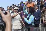 Menteri Pertahanan Prabowo Subianto (kedua kanan) tos tangan dengan Ketua Umum Pandu Laut Nusantara Susi Pudjastuti (kanan) di Pesisir Pantai Barat, Kabupaten Pangandaran, Jawa Barat, Senin (17/7/2023). Dalam kunjungannya Prabowo Subianto memberikan bantuan 20 mesin kapal untuk nelayan dan melepasliarkan ratusan tukik di pesisir Pantai Pangandaran. ANTARA FOTO/Adeng Bustomi/agr