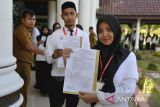 Pegawai Pemerintahan dengan Perjanjian Kerja (PPPK) memperlihatkan Surat Keputusan (SK) pengangkatan perjanjian kerja usai penyerahan di kantor Pemerintahan provinsi Aceh, Banda Acegh, Selasa (18/7/2023). Pemerintah provinsi Aceh menyerahkan Surat Keputusan (SK) Pengangkatan kepada sebanyak 1.717 tenaga kesehatan yang dinyatakan lulus sebagai Aparatur Sipil Negara (ASN) Pegawai Pemerintahan dengan Perjanjian Kerja (PPPK) . ANTARA FOTO/Ampelsa.ANTARA FOTO (ANTARA FOTO)