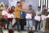 Wali Kota Kediri Abdullah Abu Bakar (ketiga kiri) secara simbolis menyerahkan Bantuan Modal Usaha (Banmod) 2023  di Kota Kediri, Jawa Timur, Senin (17/7/2023). Pemerintah daerah setempat menyerahkan Banmod 2023 dari dana bagi hasil cukai hasil tembakau (DBHCHT) kepada 10.150 peserta masing-masing sebesar Rp2,4 juta. ANTARA Jatim/Prasetia Fauzani/zk