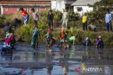 Warga menangkap ikan saat tradisi Gogoh Ikan atau menangkap ikan di Desa Tambak, Indramayu, Jawa Barat, Jumat (21/7/2023). Tradisi itu digelar masyarakat desa setempat saat merayakan tahun baru Hijriyah. ANTARA FOTO/Dedhez Anggara/agr