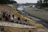 Sejumlah orang berada di kawasaan Sungai Madiun di Kota Madiun, Jawa Timur, Selasa (25/7/2023). Sejak sebulan terakhir, air Sungai Madiun yang merupakan anak Bengawan Solo itu terus menyusut hingga sebagian dasar sungainya tampak mengering akibat musim kemarau. ANTARA Jatim/Siswowidodo/ZK