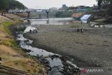  Sejumlah orang berada di kawasaan Sungai Madiun di Kota Madiun, Jawa Timur, Selasa (25/7/2023). Sejak sebulan terakhir, air Sungai Madiun yang merupakan anak Bengawan Solo itu terus menyusut hingga sebagian dasar sungainya tampak mengering akibat musim kemarau. ANTARA Jatim/Siswowidodo/ZK