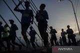 Peserta melintasi jembatan layang Prof Mochtar Kusumaatmadja saat mengikuti  Pocari Sweat Run 2023 di Bandung, Jawa Barat, Minggu (30/7/2023). Kegiatan yang diselenggarakan oleh Pemerintah Provinsi Jawa Barat bersama Pocari Sweat tersebut diikuti secara serentak oleh 11.875 peserta yang berlari secara luring di Kota Bandung dan 15.523 peserta di 404 kota seluruh Indonesia yang berlari secara daring dengan kategori Marathon, Half Marathon, dan 10 Kilometer. ANTARA FOTO/Novrian Arbi/agr