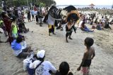 Pengunjung menyaksikan sejumlah pemuda umat Hindu mementaskan tarian barong bangkung saat tradisi Ngelawang dalam rangkaian perayaan Hari Raya Galungan di Pantai Sanur, Denpasar, Bali, Kamis (3/8/2023). Tradisi yang digelar setiap Hari Raya Galungan dan Kuningan tersebut merupakan ritual tolak bala untuk menetralisir aura negatif sekaligus menghibur pengunjung di objek wisata itu. ANTARA FOTO/Nyoman Hendra Wibowo/wsj.
